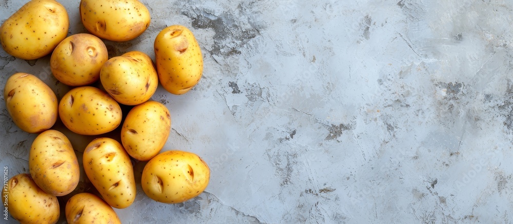 Poster potatoes placed on concrete background, seen from above with empty space around.