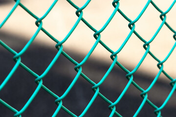 Fototapeta premium Close-up green metal chain link fence with blurred background