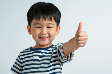 Happy little cute Asian boy giving thumbs up on white background