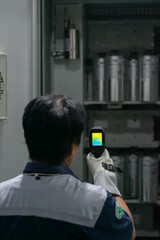 Professional Electrician use thermal infrared camera or thermometer scanning electrical system for...
