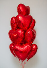 red heart balloons with helium on a white background in a bunch