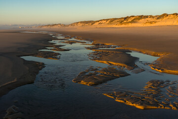 Sunset landscape of the Viago beach in Pedrogao, Figueira da Foz, Portugal, with the clouds reflected on the water.