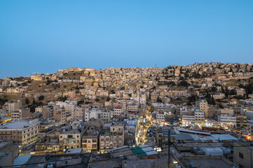 Captivating skyline of Amman, Jordan traditional houses atop a picturesque hill during blue hour - 737103414