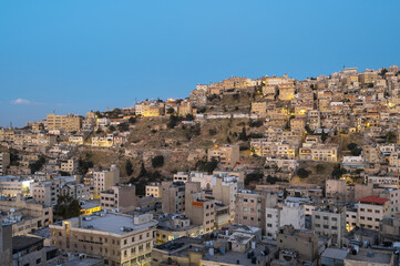 Captivating skyline of Amman, Jordan traditional houses atop a picturesque hill during blue hour - 737103454