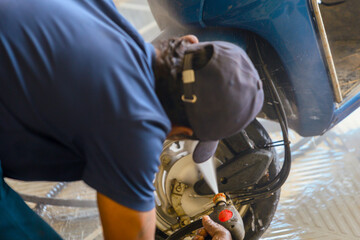 mechanic repairing a motorbike in a car repair shop
