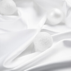 White Christmas baubles decoration on white silk background. Holiday concept.