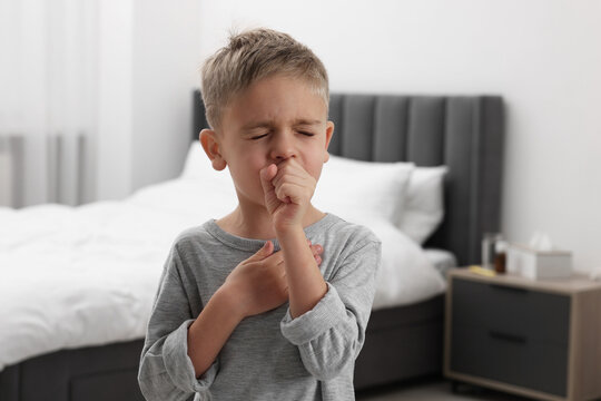 Sick boy coughing at home. Cold symptoms