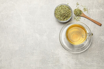 Aromatic fennel tea and seeds on light grey table, flat lay. Space for text