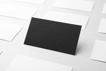 Blank black and white business cards on light background, closeup. Mockup for design