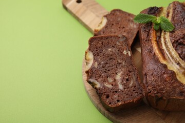 Delicious banana bread with mint on green background, closeup. Space for text