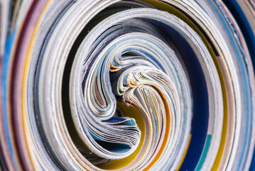Macro view of old rolled up colored newspapers