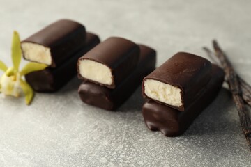 Glazed vanilla curd cheese bars on grey table, closeup