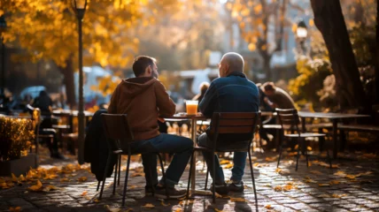Foto op Canvas Two people sitting at a café table in autumn, representing conversation, friendship, relaxation and season change. © mr_marcom