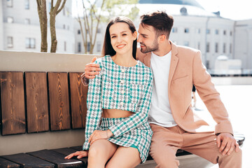 Obraz premium Beautiful fashion woman and her handsome elegant boyfriend in beige suit. Sexy brunette model in summer clothes. Fashionable smiling couple posing in street Europe. Brutal man and female outdoors