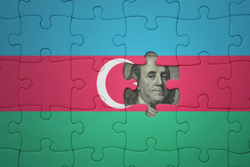 puzzle with the national flag of azerbaijan and usa dollar banknote. finance concept