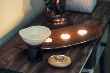 oil aroma lamp with candles and roller massager on a wooden table
