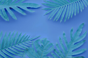 A blue background with cutouts of tropical leaves, including palm and monstera, arranged in the foreground