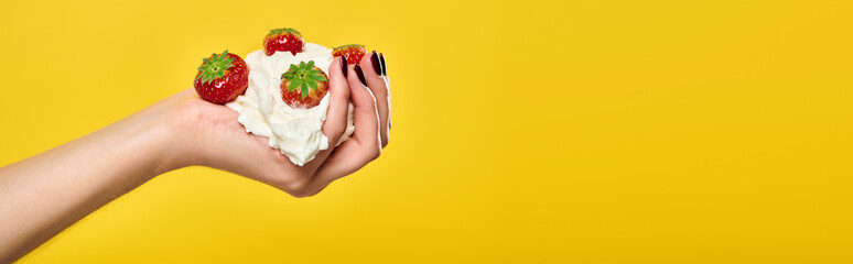 object photo of juicy red strawberries in whipped cream in hands of unknown female model, banner - obrazy, fototapety, plakaty