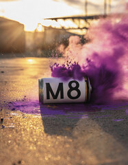 Purple spray can with an M8 exploding as it falls to the ground like a smoke bomb in reference to...