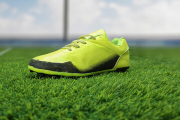 green and black football shoe on the green grass