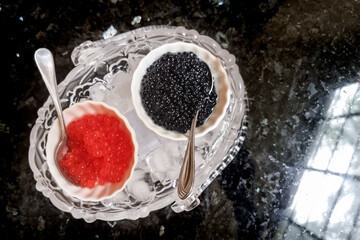 Overhead view of delicuous but expensive red and black caviar on tray of ice