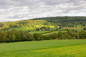 Fototapeta na wymiar Summer landscape view, Hilly countryside of Zuid-Limburg with small villages on the hillside, farmland and forest, Epen is a village in the southern part of the Dutch province of Limburg, Netherlands.