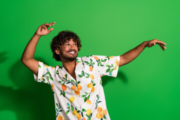 Photo of funky dreamy arabian man wear print shirt dancing looking empty space isolated green color...