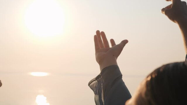 People hands reach out to sun at sunrise. 