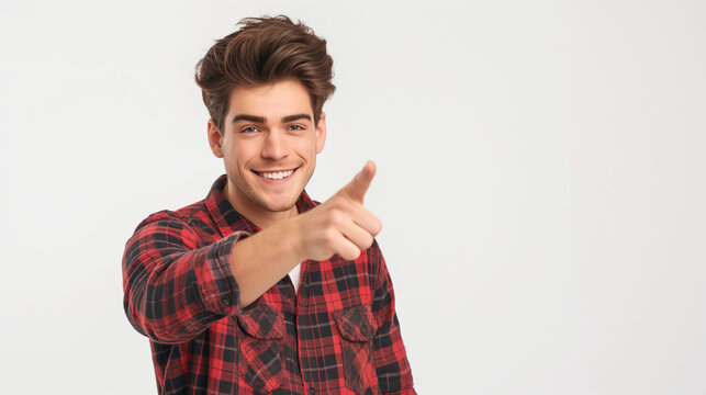 Young man on white background pointing ahead with a smile. Jeune homme sur fond blanc montrant du doigt devant lui avec le sourire.