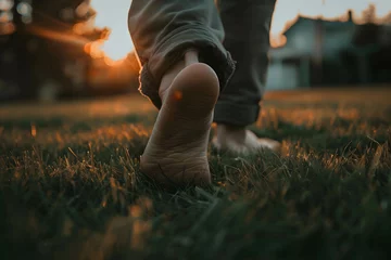 Fotobehang close up of the bare feet of a person walking on the grass, therapy and reduce stress in living and investing and doing business © Slowlifetrader