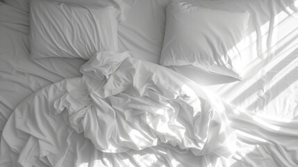 a black and white photo of a bed with a white comforter on top of it and pillows on the bottom of the bed.
