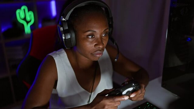 Focused woman enjoying video gaming at home with a controller at night, illustrating modern entertainment.