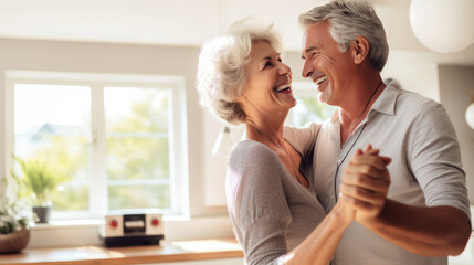Joyful senior couple dancing and laughing together in a bright home