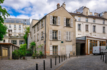 Cozy street in quarter Montmartre in Paris, France. Architecture and landmarks of Paris. Postcard of Paris - 737187204
