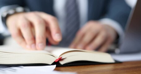Businessman examines daily planner at workplace. Business planning concept