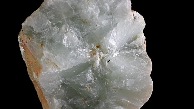 Prehnite (inosilicate of calcium and aluminium with the formula Ca2Al2) nodule rotating slowly against a black background.	