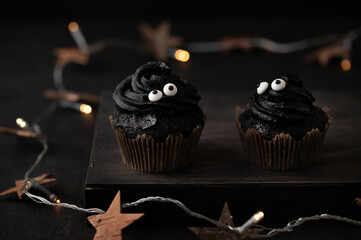 Festive black Halloween cupcakes decorated with sprinkles. Halloween muffins. Halloween creative...