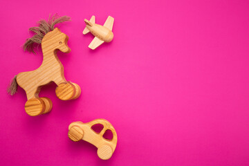 Wooden horse on pink background. Eco-friendly. Greeting card. Flat lay