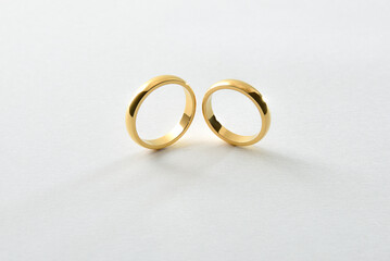 Engagement gold rings standing next to each other isolated white