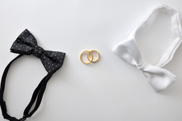 Two bow ties and wedding rings in the middle