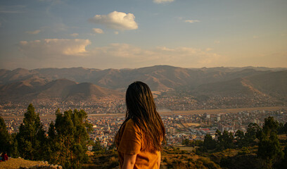 
beautiful woman with long hair looking at the horizon, distant city with distant mountains and...
