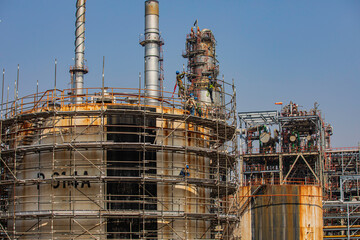 Construction workers installing scaffolding storage tank Oil​ refinery​ and​ plant and tower column