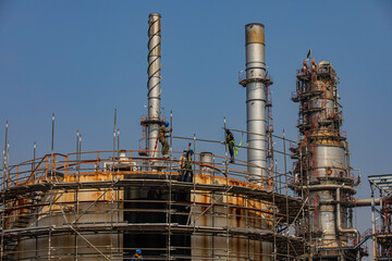 Construction workers installing scaffolding storage tank Oil​ refinery​ and​ plant and tower column