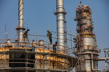 Construction workers installing scaffolding storage tank Oil​ refinery​ and​ plant and tower column