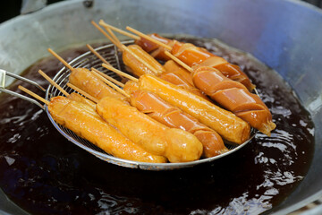 Fried sausage in hot pan at street food market, Thailand. pork ball.