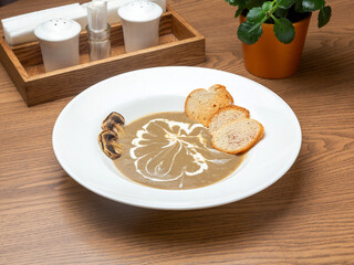 Mushroom soup with croutons in a plate. Lunch.