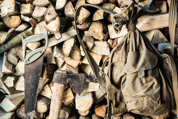 old military bag,firewood, hand saw and ax
