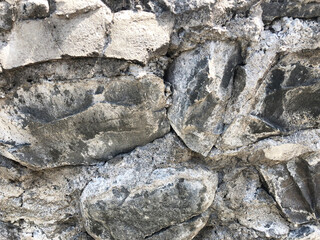 Background of stone wall texture photo.Fragment of a wall from a chipped stone.Background.Real photo.