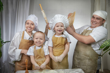 Cute oriental family with mother, father, daughter, son cooking in the kitchen on Ramadan, Kurban-Bairam, Eid al-Adha. Funny fighting parents at cook photoshoot. Pancakes, pastries, Maslenitsa, Easter