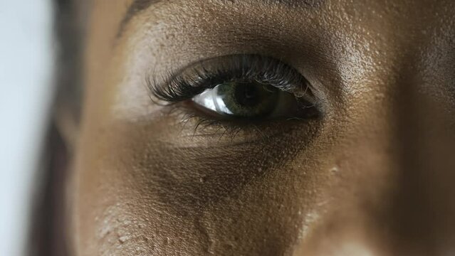 Macro shot of female model face. African American woman macro shot of the face parts eyes and lips, model looks at the camera.